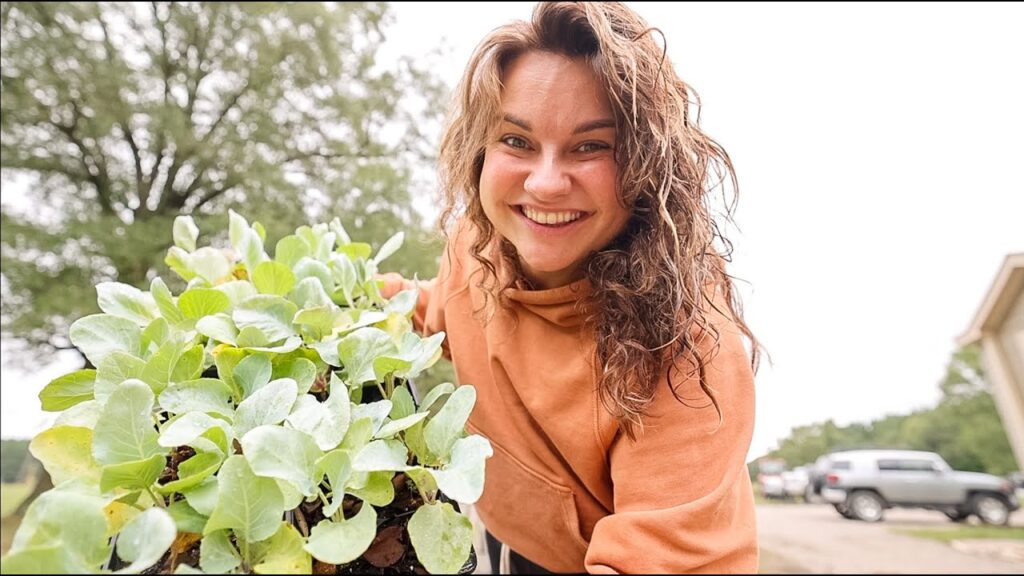 Image of a woman holding up vegetables from the garden.