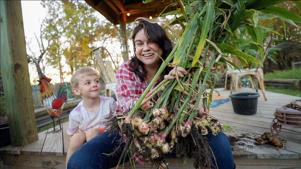 A woman and her son holding up a harvest of ginger.