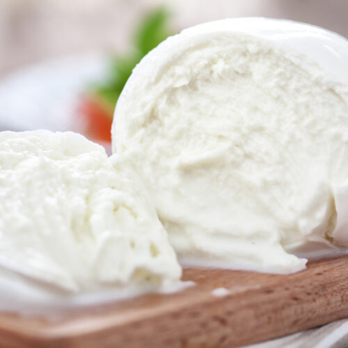 Mozzarella cheese ball on a wooden cutting board.