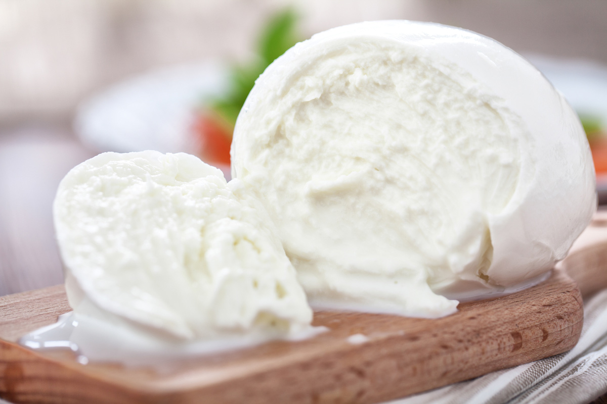 Mozzarella cheese ball on a wooden cutting board.