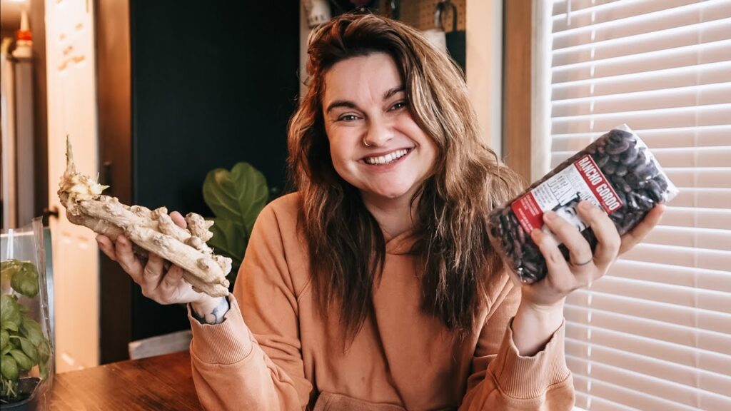 Woman holding up grocery store items.