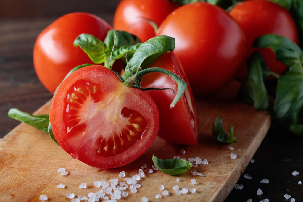 Upclose photo of a tomato sliced open on a cutting board.