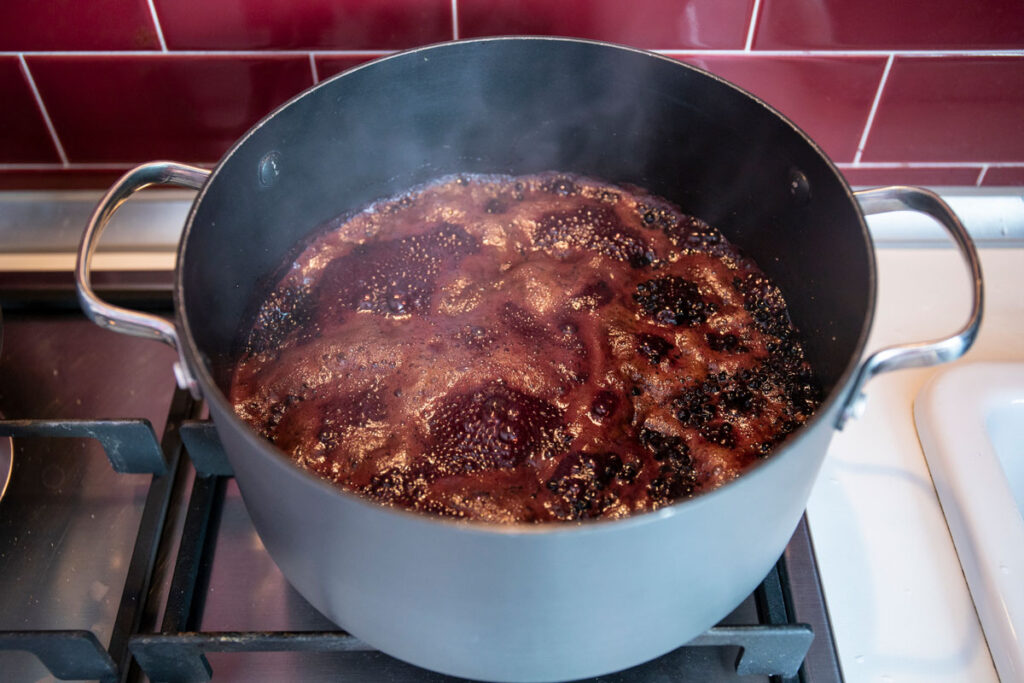 Elderberry syrup cooking on a stovetop.