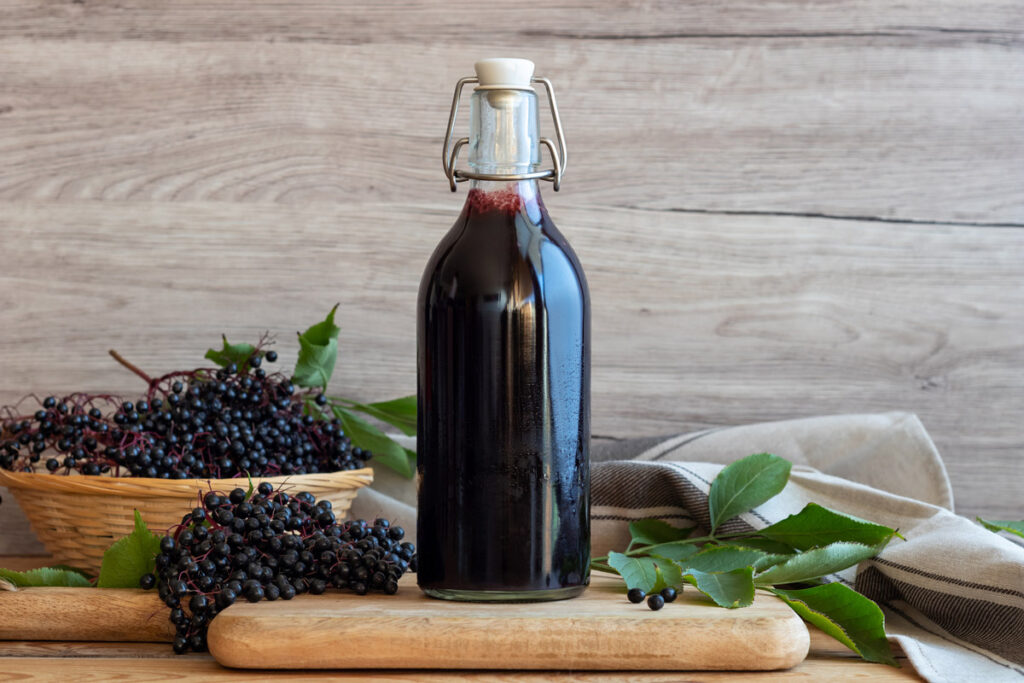 Elderberry syrup in a swing top bottle on a counter.