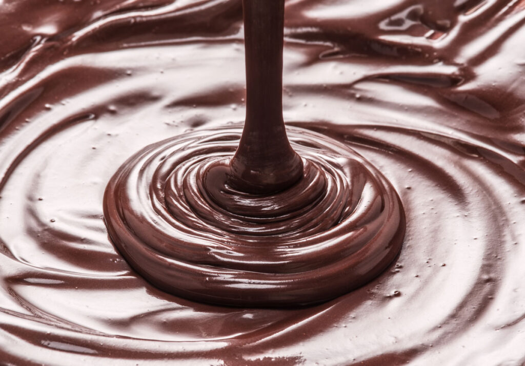 Chocolate pudding being poured into a pie crust.