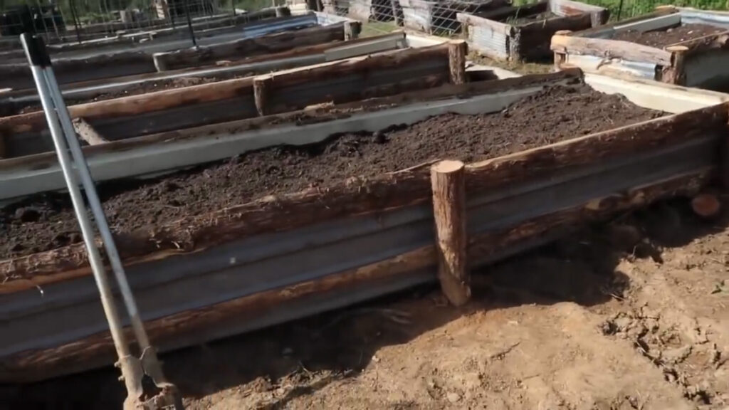 A completed DIY raised garden bed filled with soil.