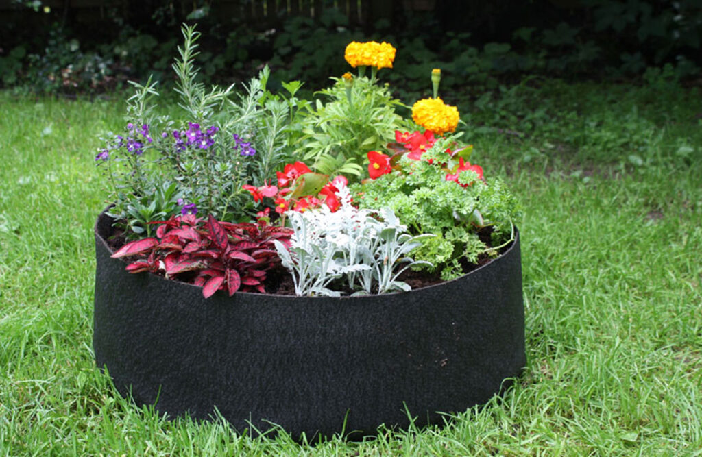 A large grow bag garden bed filled with flowers.