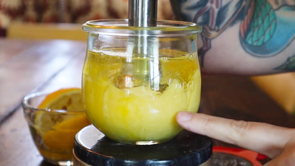 Mayonnaise being blended with an immersion blender in a Weck jar.