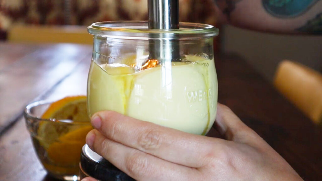 An immersion blender making mayo in a jar.