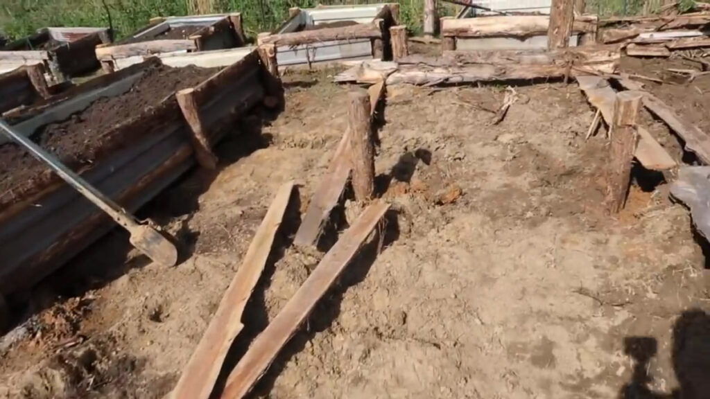 Long pieces of rough sawn lumber lined up for a DIY raised garden bed.