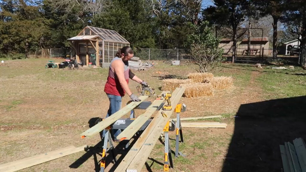 A man cutting pieces of lumber.
