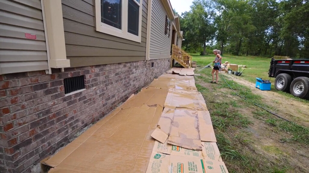 Cardboard laid out to kill back grass and weeds to prepare a raised garden bed.