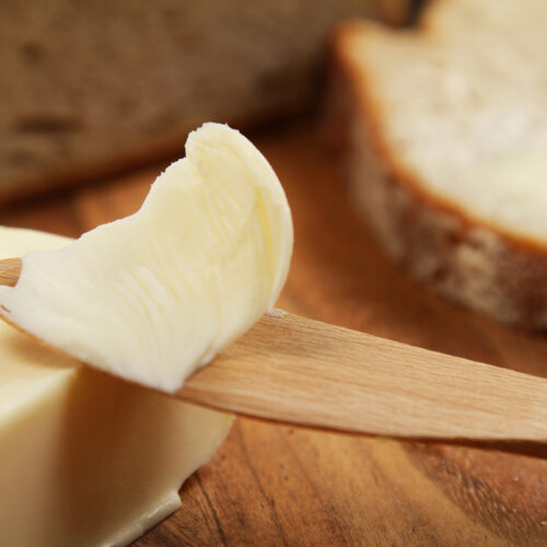 Homemade butter on a wooden knife.