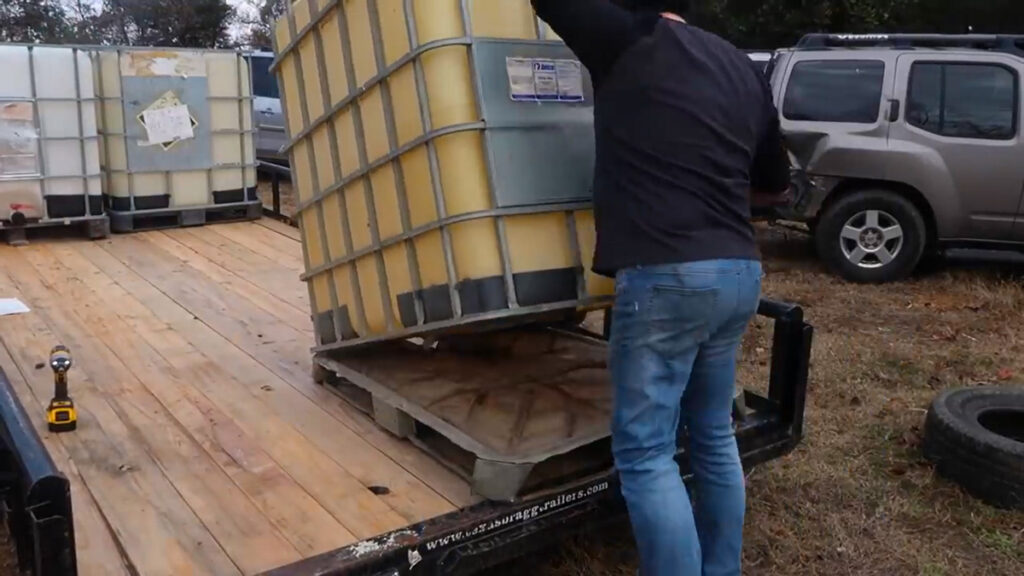 A man removing the base off an IBC.