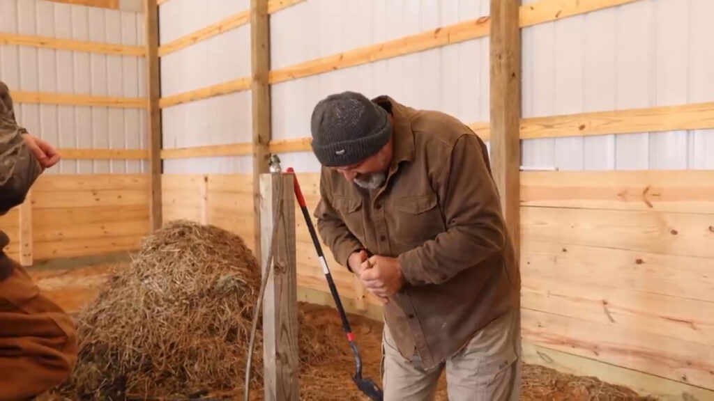 A man squeezing water out of compost.