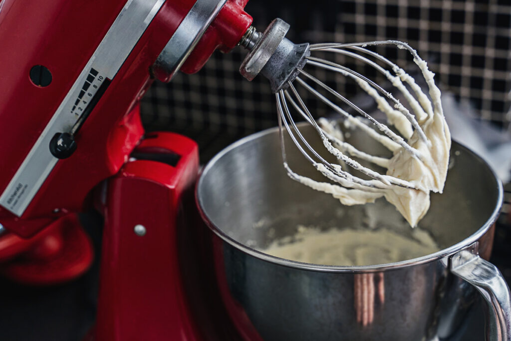 Whipped cream in a stand mixer for making butter.