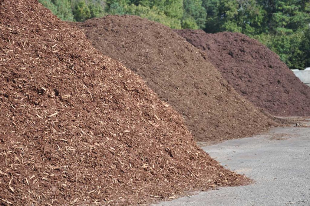 Three large heaps of woodchips.