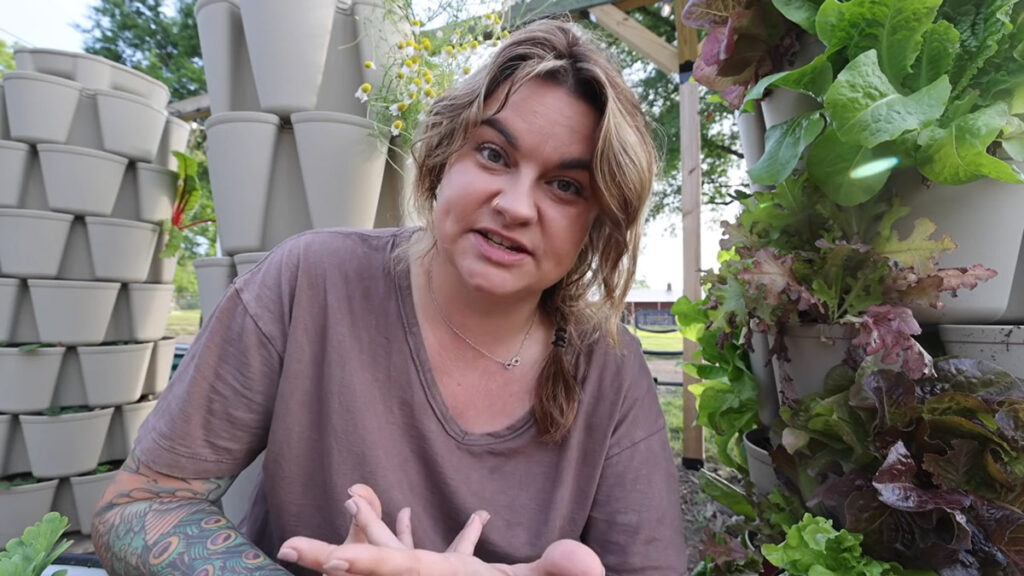 A woman sitting in front of multiple GreenStalk planters.