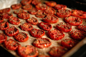 Sliced dehydrated tomatoes on a cookie sheet.