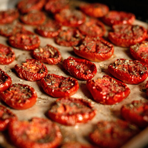Sliced dehydrated tomatoes on a cookie sheet.