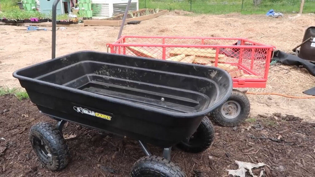 Two wheel barrows in a garden.