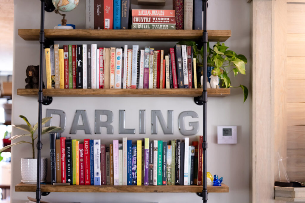 A bookshelf filled with books and the word "Darling" on the wall.