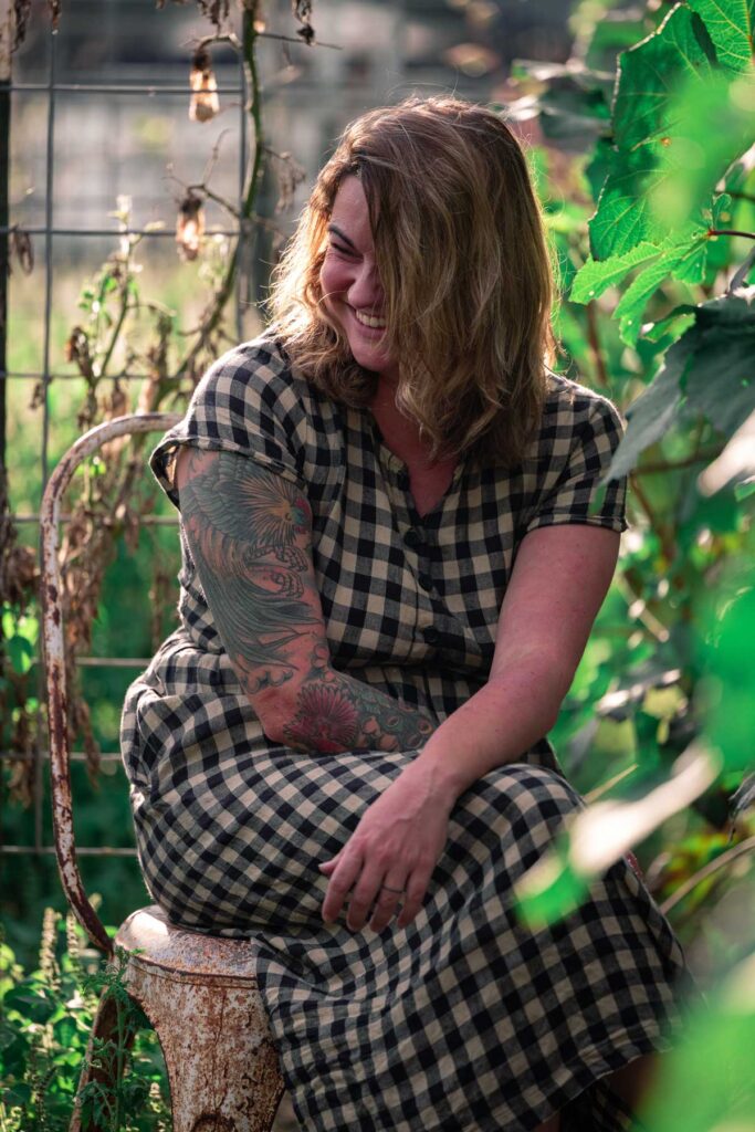 A woman laughing sitting in the garden.