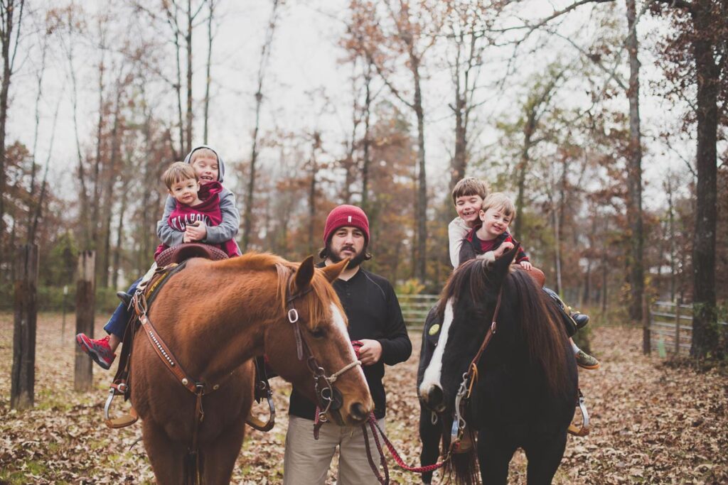 A father and sons on horseback.