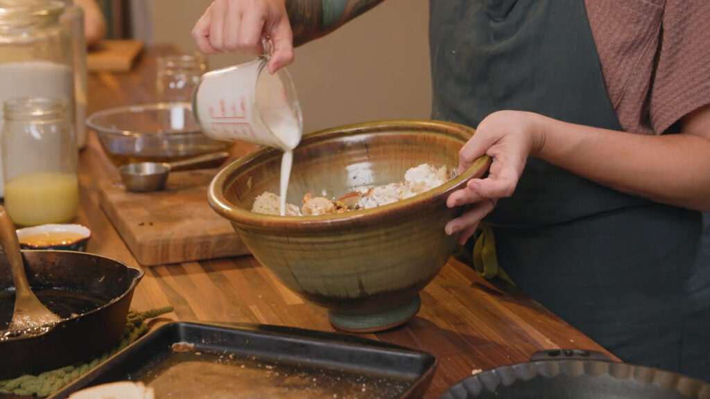 A woman pouring cream into a bowl.