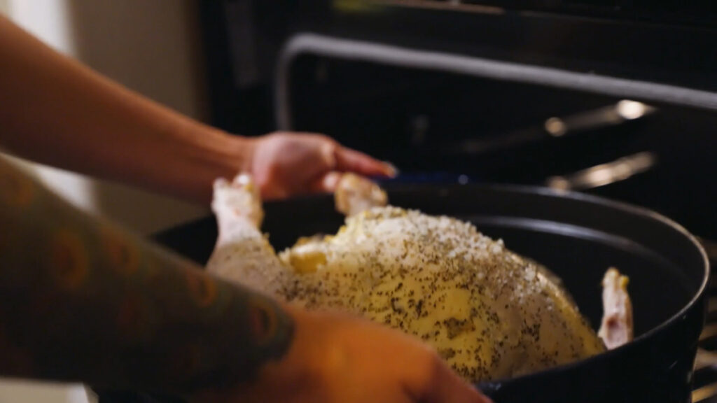 Putting a turkey in a roasting pan into the oven.