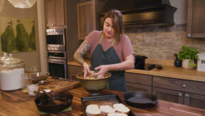 A woman mixing stuffing with her hands.