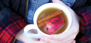 A mug of wassail in a white cup.