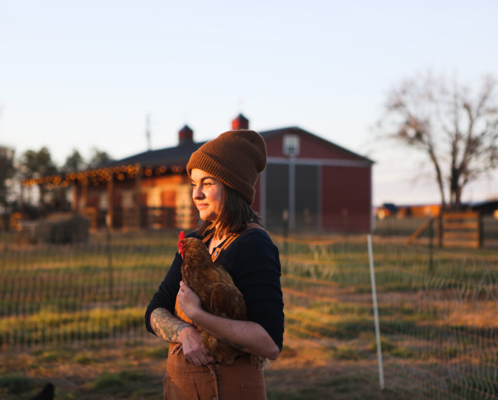 A woman holding a chicken.