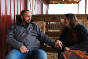 A man and woman holding hands, sitting in rocking chairs.